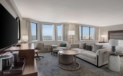 Beautiful king suite with work desk, TV, and sofa at Hilton Crystal City At Washington Reagan National Airport.