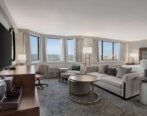 Beautiful king suite with work desk, TV, and sofa at Hilton Crystal City At Washington Reagan National Airport.