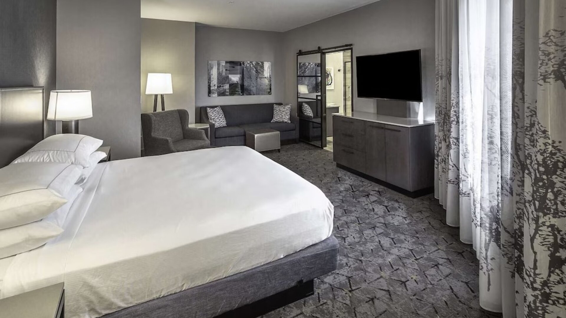King size bed and sofa in a day use room at DoubleTree By Hilton Modesto.