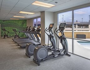 Fitness center with a view of the pool at DoubleTree By Hilton Modesto.