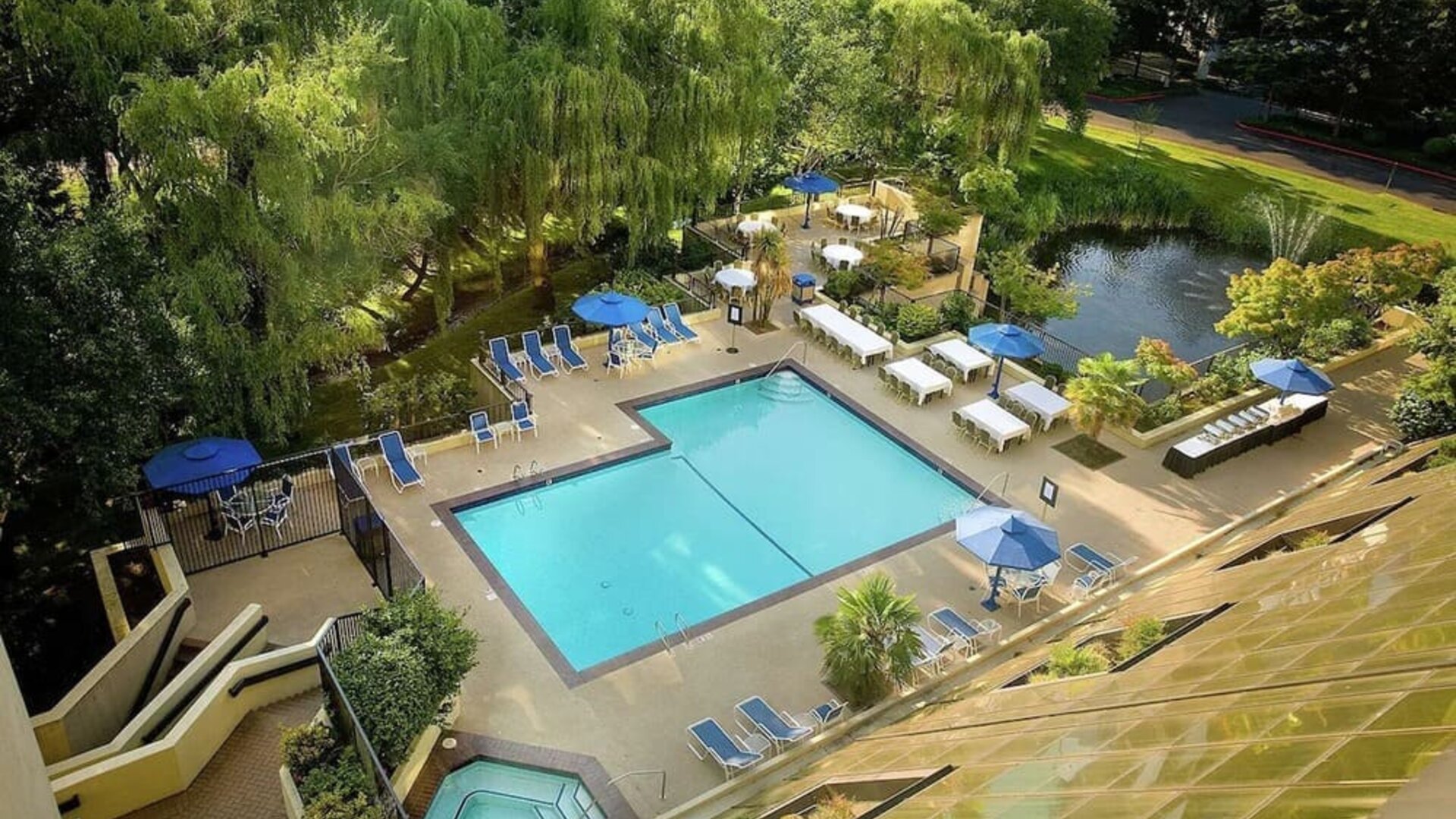 Seasonal outdoor pool and jacuzzi surrounded by sun loungers at Hilton Bellevue.