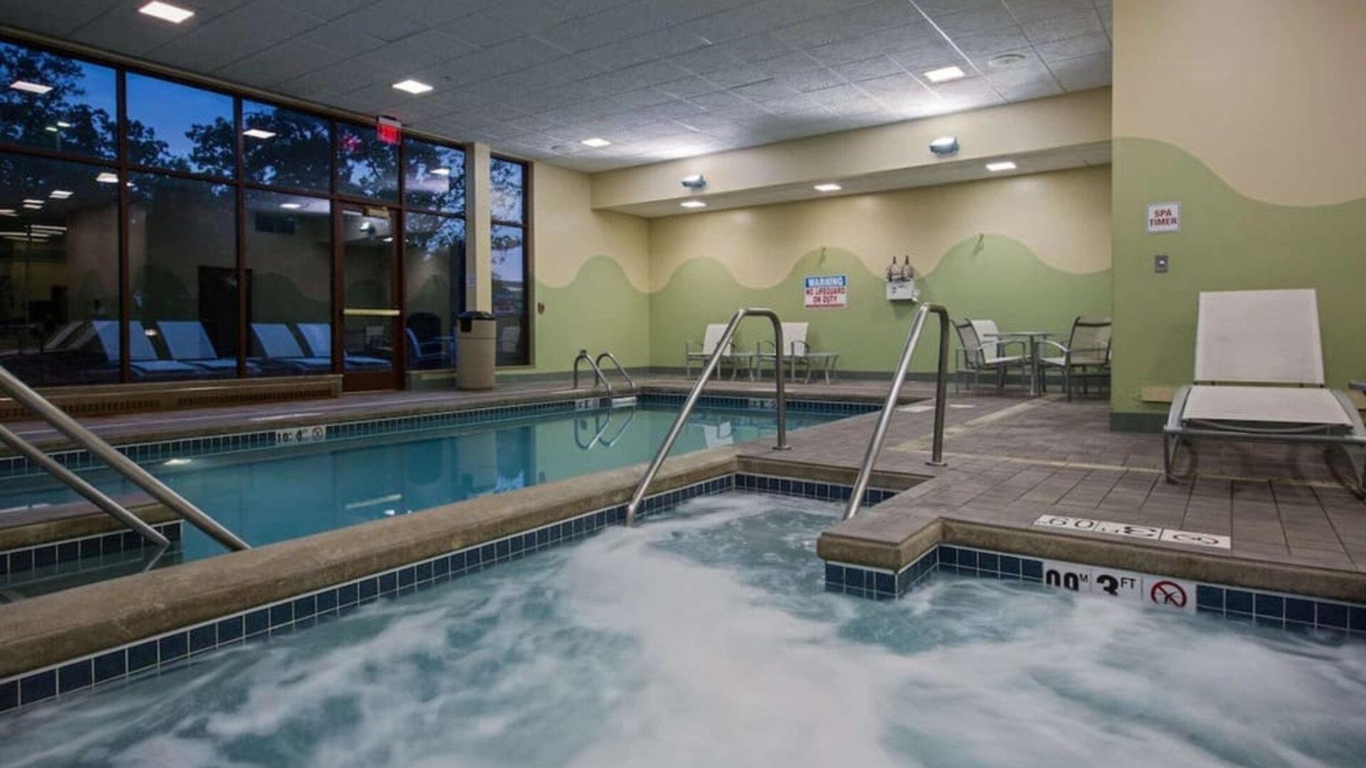 Relaxing indoor pool with lounge chairs at Sonesta Milwaukee West Wauwatosa.