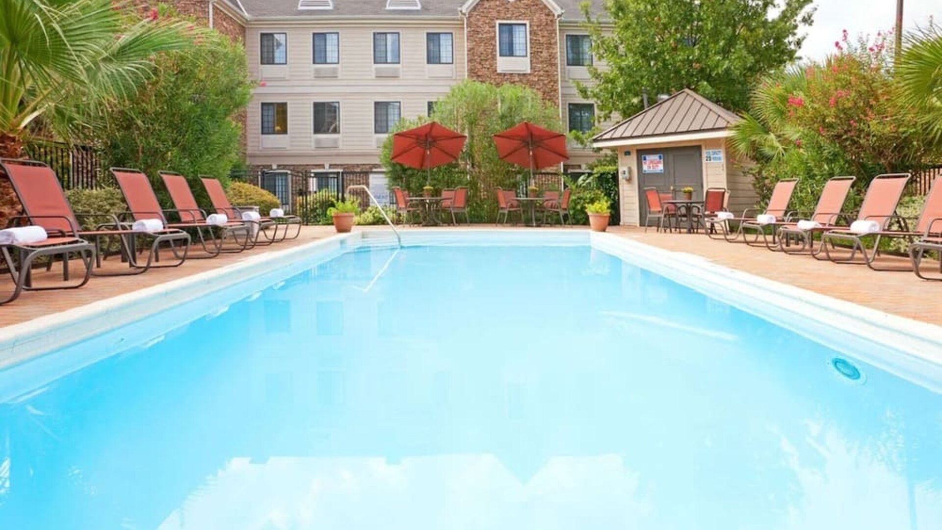 Outdoor pool with lounge chairs at Sonesta ES Suites Dallas Las Colinas.