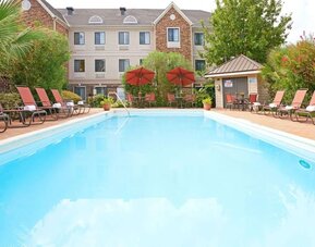 Outdoor pool with lounge chairs at Sonesta ES Suites Dallas Las Colinas.