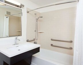 Private guest bathroom with combined shower and tub at Sonesta Simply Suites Dallas Las Colinas.
