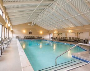 Refreshing indoor pool surrounded by loungers at DoubleTree By Hilton Grand Rapids Airport.
