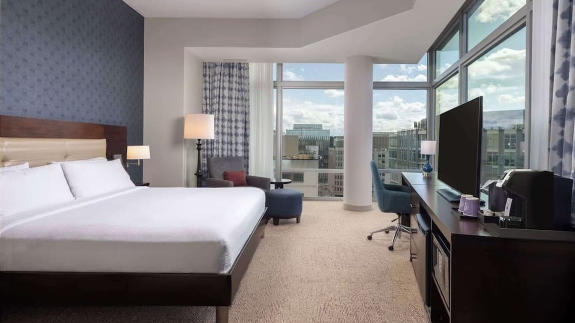 Bright king room with work station and a view of the city at Hilton Garden Inn Washington DC/Georgetown Area.
