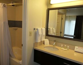 Private guest bathroom with combined shower and tub at Sonesta ES Suites Portland Vancouver 41st Street.