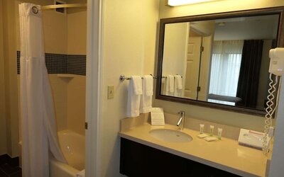 Private guest bathroom with combined shower and tub at Sonesta ES Suites Portland Vancouver 41st Street.