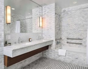 Private guest bathroom with combined shower and tub at Nautilus Sonesta Miami Beach.