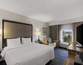 Comfortable king room with sofa and work desk at Hampton Inn Bloomington.