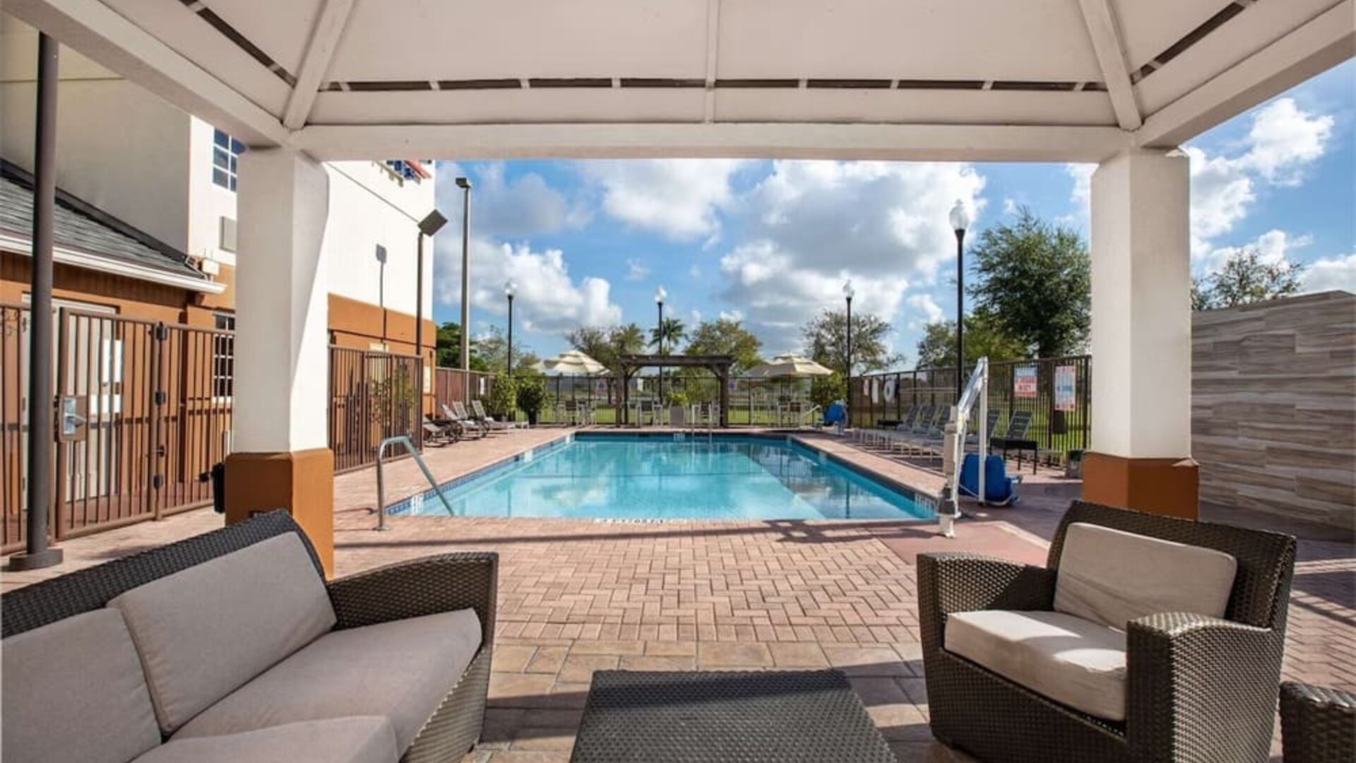 Outdoor pool with lounge area at Sonesta Simply Suites Miami Airport Doral. 