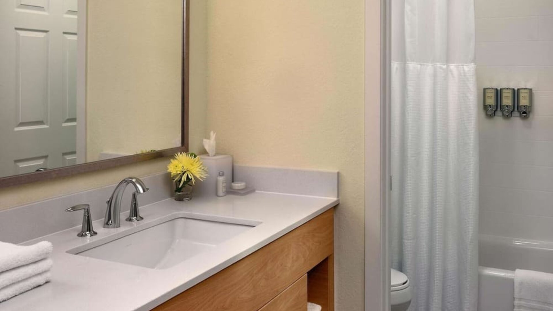Private guest bathroom with combined shower and tub at Sonesta ES Suites Flagstaff.