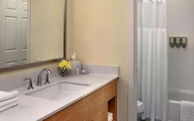 Private guest bathroom with combined shower and tub at Sonesta ES Suites Flagstaff.