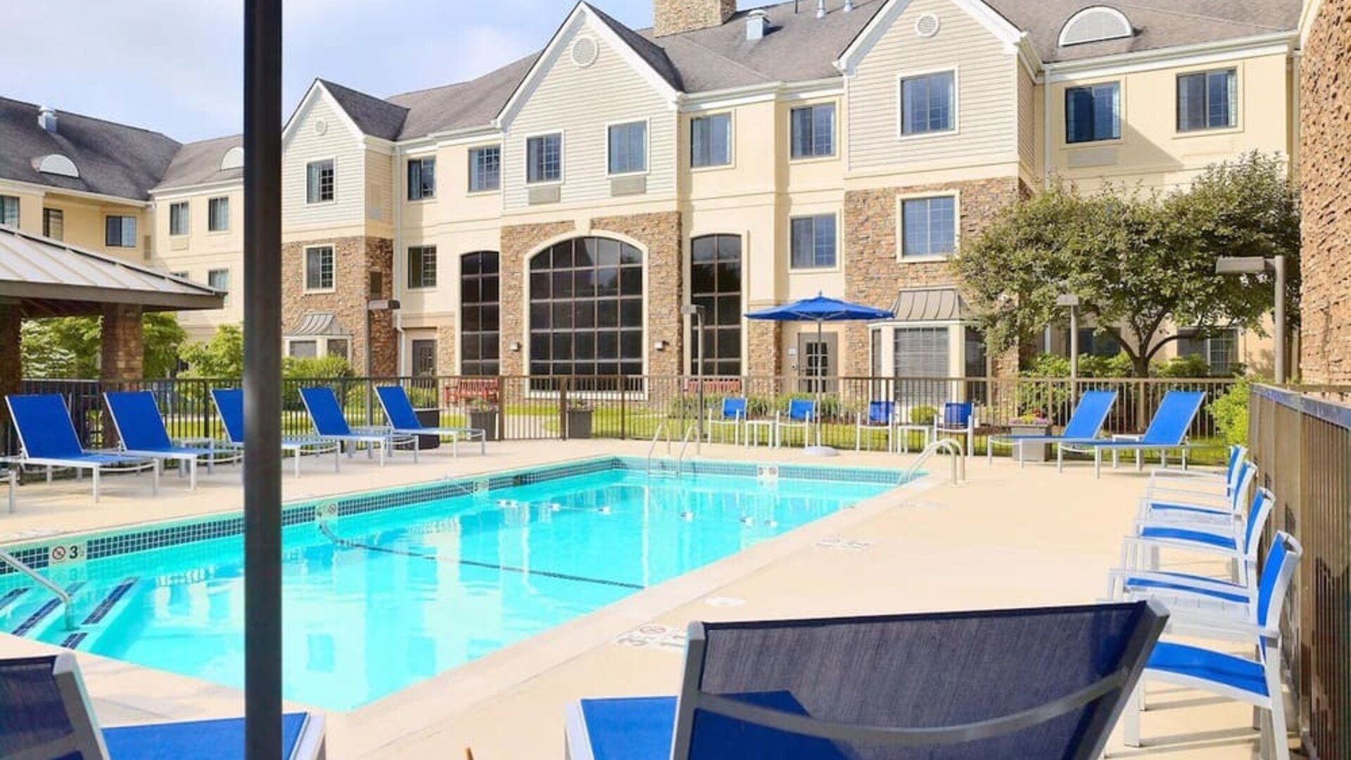 Outdoor pool with lounge chairs at Sonesta ES Suites Charlotte Arrowood.