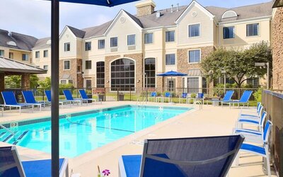 Outdoor pool with lounge chairs at Sonesta ES Suites Charlotte Arrowood.