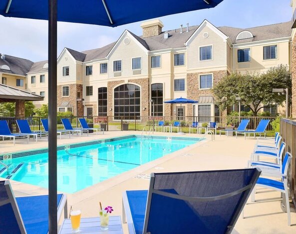 Outdoor pool with lounge chairs at Sonesta ES Suites Charlotte Arrowood.
