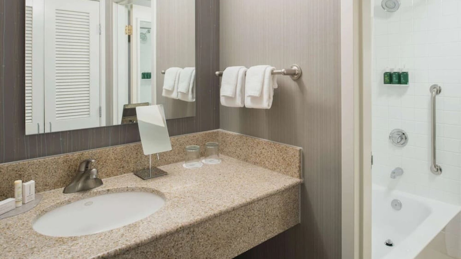 Private guest bathroom with combined shower/tub and free toiletries at Sonesta Select Seattle Bellevue Redmond.