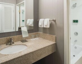 Private guest bathroom with combined shower/tub and free toiletries at Sonesta Select Seattle Bellevue Redmond.
