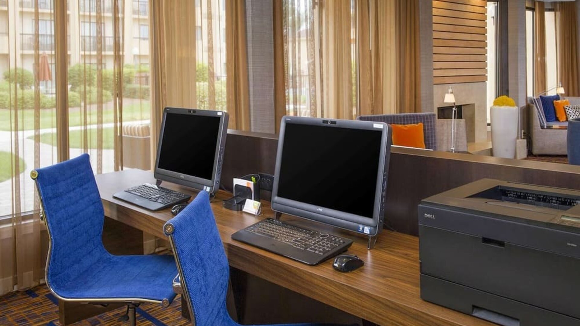 Business center with computers, printer and ergonomic chairs at Sonesta Select Charlotte University Research Park.