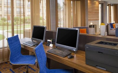 Business center with computers, printer and ergonomic chairs at Sonesta Select Charlotte University Research Park.