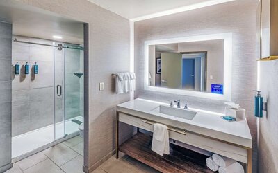 Guest bathroom with shower at DoubleTree By Hilton Tulsa-Downtown.
