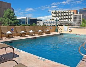 Refreshing outdoor pool surrounded by sunbeds at DoubleTree By Hilton Albuquerque.