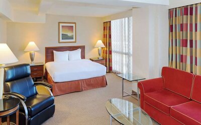 King size suite with sound proofed windows and lounger at Hilton Chicago O'Hare Airport.