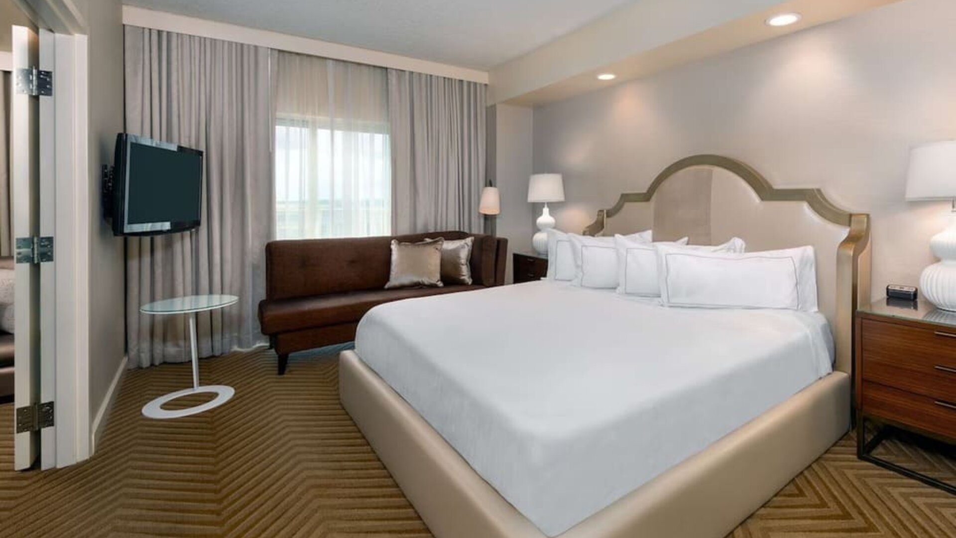 Comfortable king size bed with living area at Hilton Charlotte Airport.
