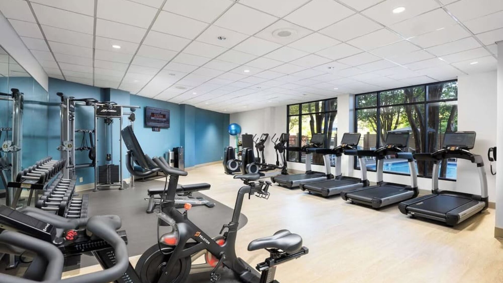Well-equipped fitness center with a view of the pool at Doubletree By Hilton Houston Medical Center Hotel & Suites.