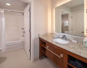 Private guest bathroom with combined shower and tub at Sonesta ES Suites Baltimore BWI Airport.