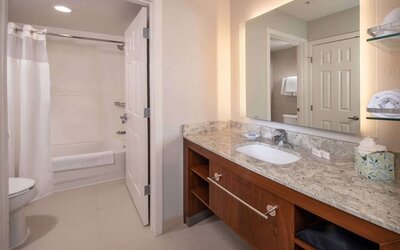 Private guest bathroom with combined shower and tub at Sonesta ES Suites Baltimore BWI Airport.