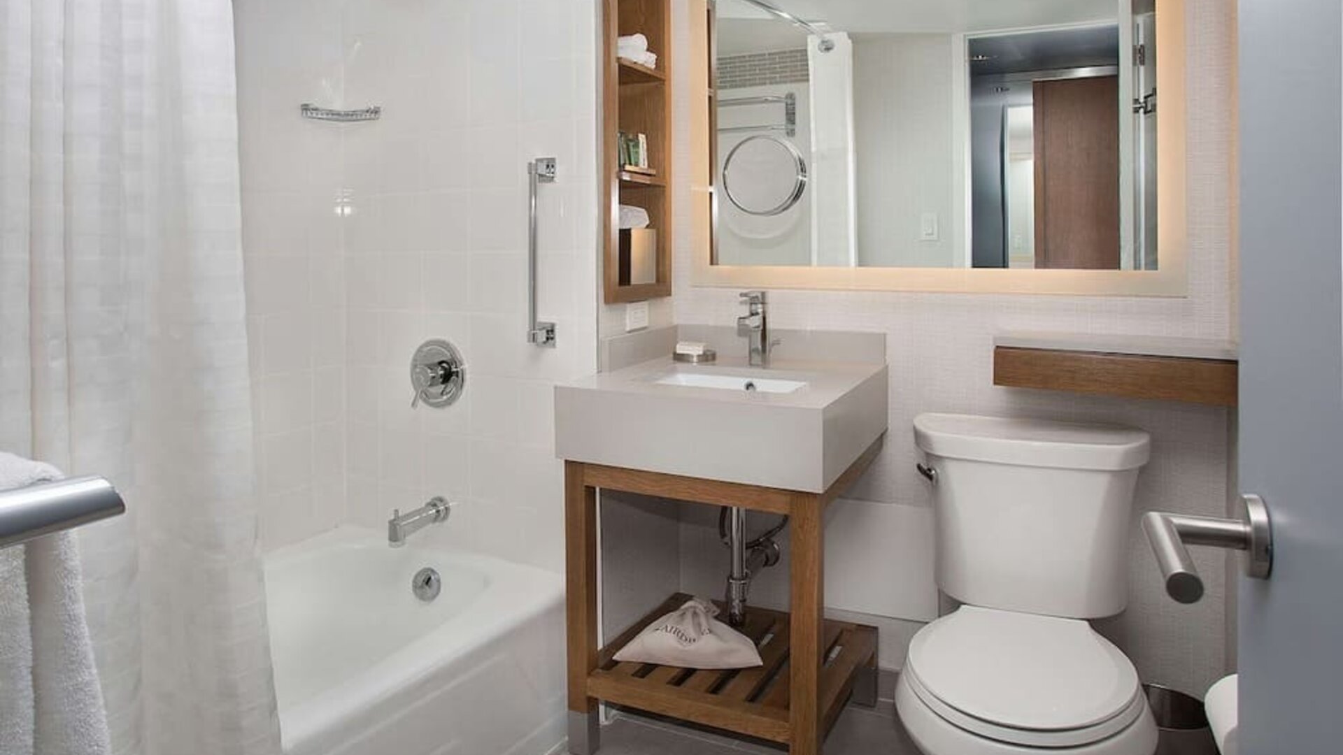 Private guest bathroom with combined shower and tub at New York Hilton Midtown.