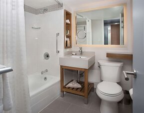 Private guest bathroom with combined shower and tub at New York Hilton Midtown.