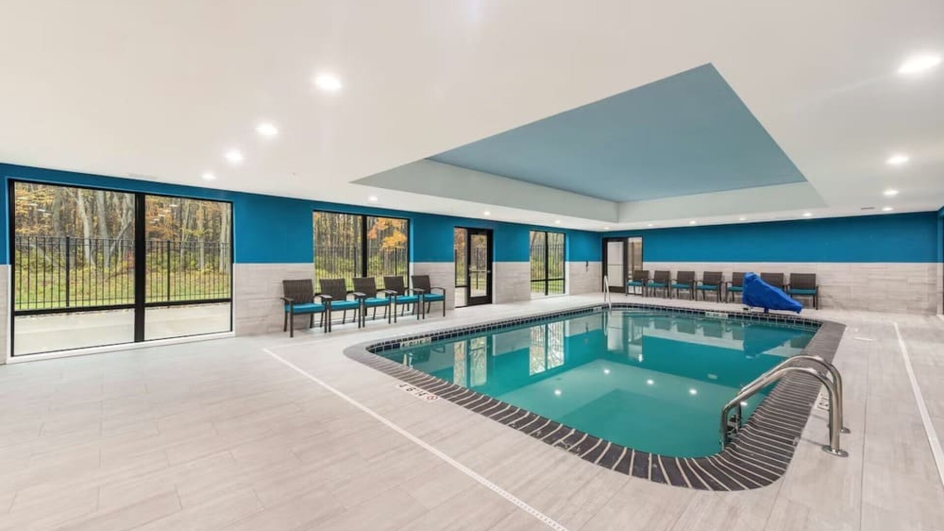 Relaxing indoor heated pool with lounge chairs at Hampton Inn & Suites Benton Harbor.