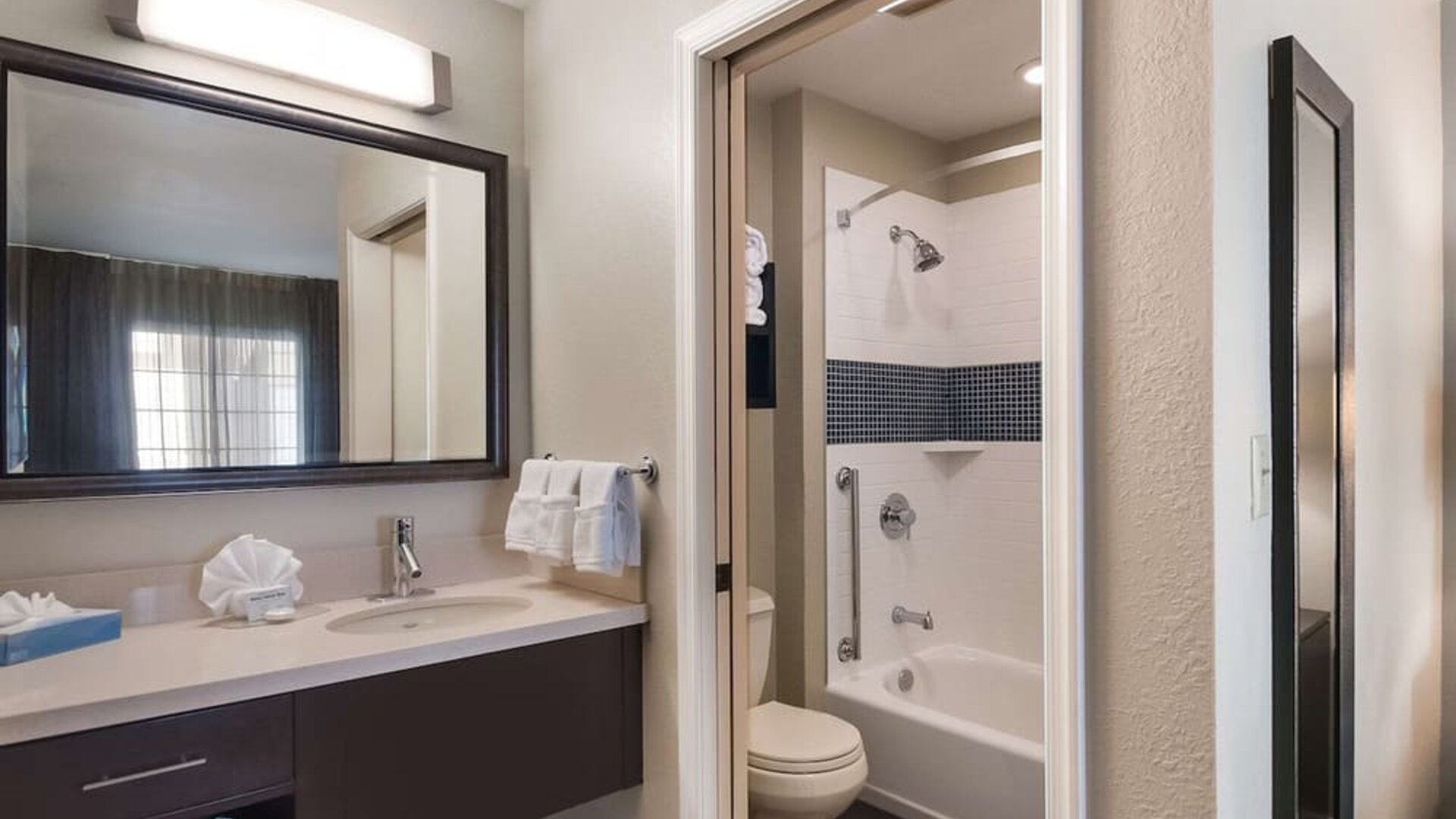 Private guest bathroom with combined shower and tub at Sonesta ES Suites Dulles Airport.