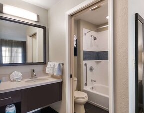 Private guest bathroom with combined shower and tub at Sonesta ES Suites Dulles Airport.