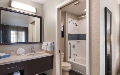 Private guest bathroom with combined shower and tub at Sonesta ES Suites Dulles Airport.