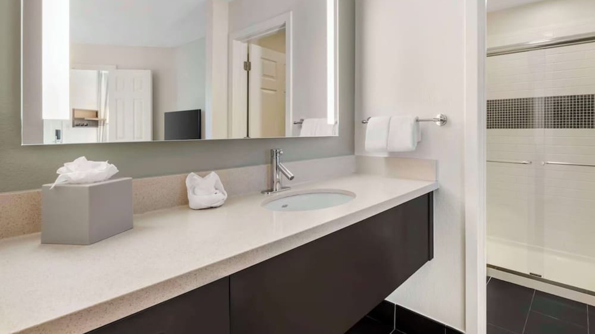 Private guest bathroom with shower and free toiletries at Sonesta ES Suites Dulles Airport.