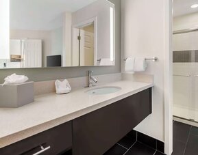 Private guest bathroom with shower and free toiletries at Sonesta ES Suites Dulles Airport.