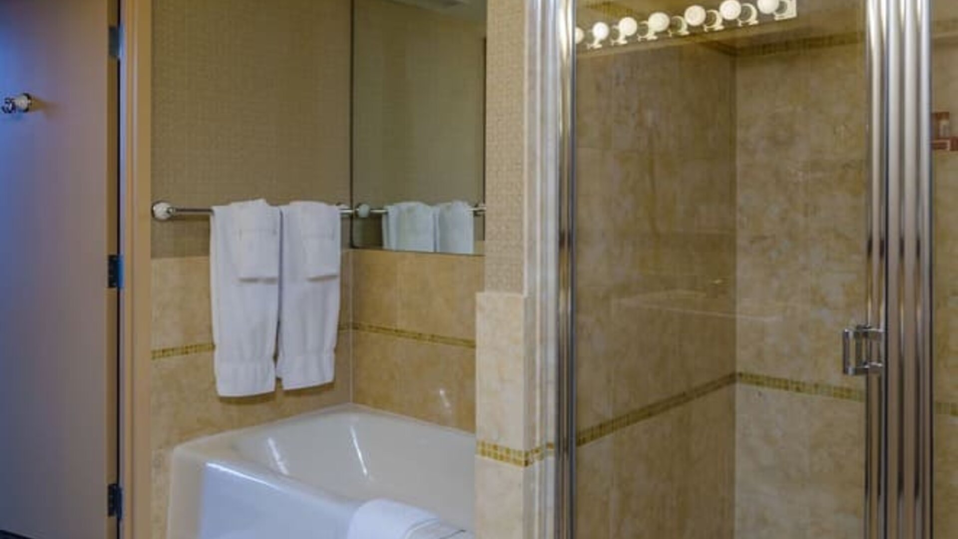 Guest bathroom with shower and tub at Beacon Hotel.