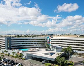 Exterior view of Sonesta Miami Airport and parking area. 