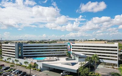 Exterior view of Sonesta Miami Airport and parking area. 