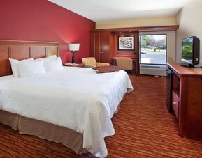 King room with TV screen, work desk and sofa at Hampton Inn Columbus-East.