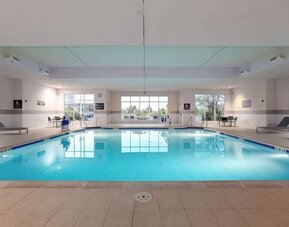 Relaxing indoor pool with lounge chairs at Hilton Garden Inn Milwaukee Northwest Conference Center.