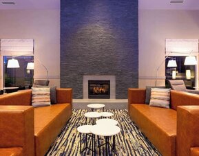 Comfortable lobby lounge with fireplace at Hilton Garden Inn Milwaukee Northwest Conference Center.
