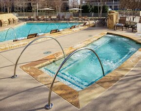 Refreshing outdoor pool and hot tub at Hilton Dallas/ Plano Granite Park.