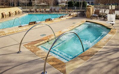 Refreshing outdoor pool and hot tub at Hilton Dallas/ Plano Granite Park.