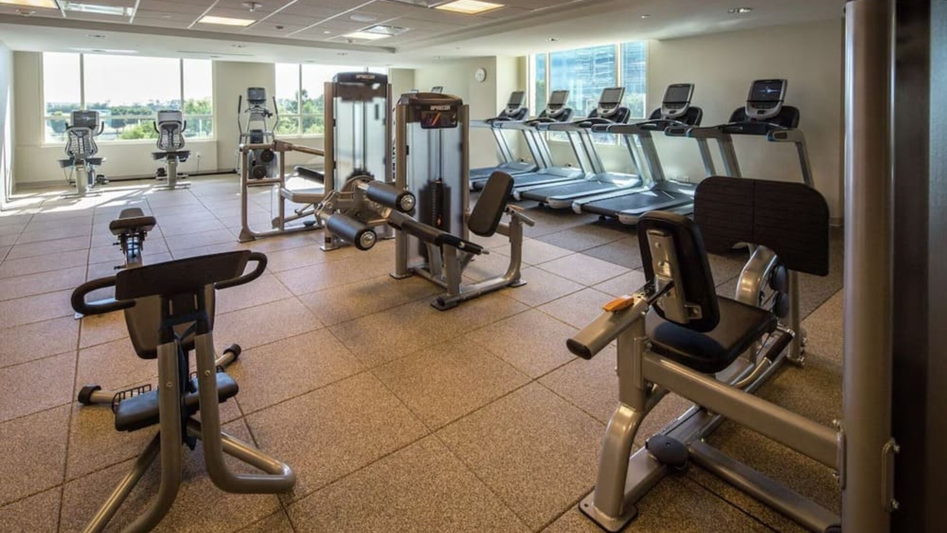Fitness center with natural light at Hilton Dallas/ Plano Granite Park.