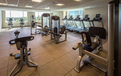 Fitness center with natural light at Hilton Dallas/ Plano Granite Park.